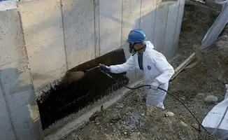 Professional waterproofing the exterior walls of the basement in Tacoma, WA